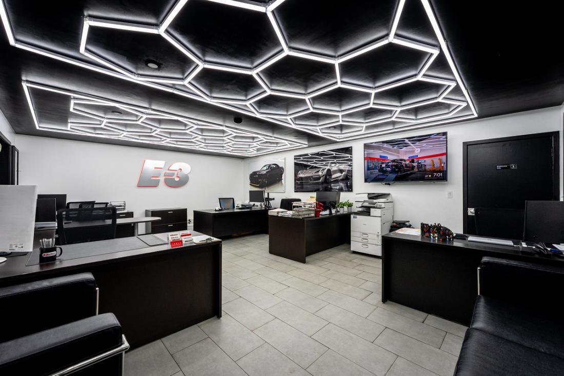 E3 Collision's modern front office and reception area with workstations and wall art