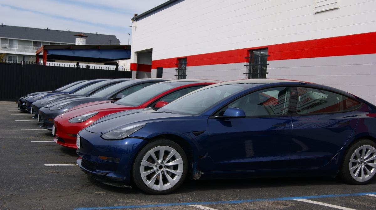 Row of Tesla vehicles parked in the lot outside E3 Collision's Long Beach location